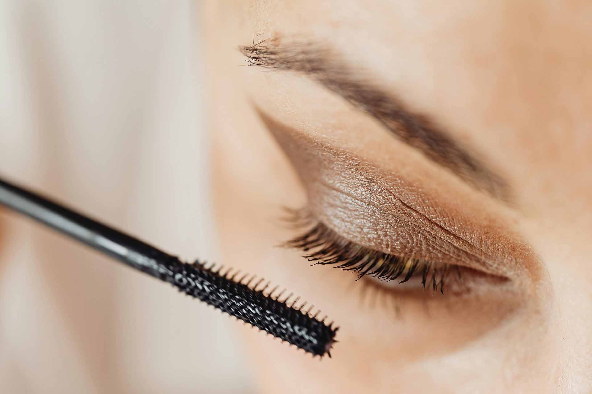 Frau beim Auftragen von Mascara